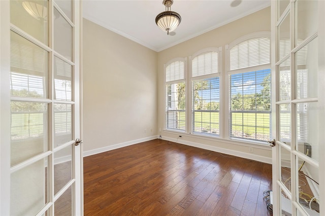 spare room featuring ornamental molding and dark hardwood / wood-style floors