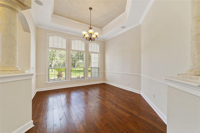 unfurnished dining area with dark wood-type flooring, crown molding, a tray ceiling, and a chandelier