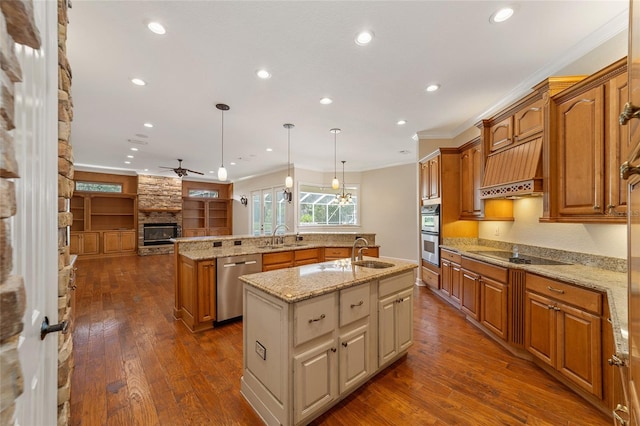 kitchen featuring a kitchen island with sink, dark hardwood / wood-style floors, stainless steel appliances, hanging light fixtures, and ornamental molding