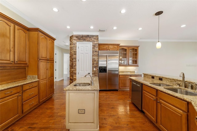 kitchen with sink, decorative light fixtures, a kitchen island with sink, appliances with stainless steel finishes, and dark hardwood / wood-style flooring