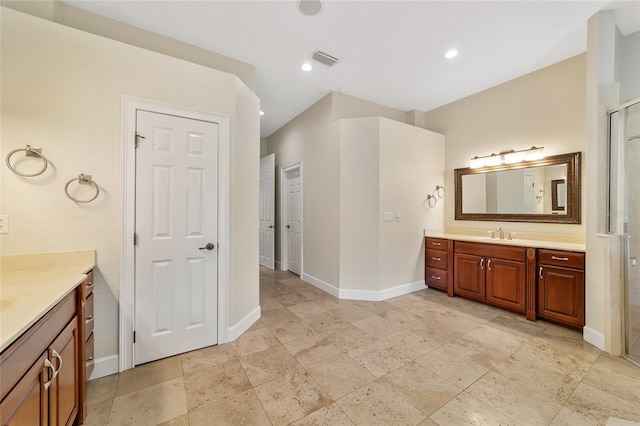 bathroom featuring a shower with door and vanity