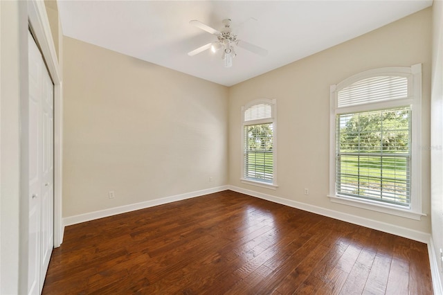 empty room with dark wood-type flooring and ceiling fan