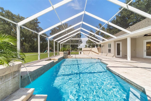 view of swimming pool featuring glass enclosure, a patio area, and ceiling fan