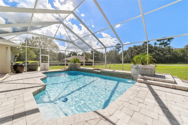 view of pool with a yard, a patio, glass enclosure, and pool water feature