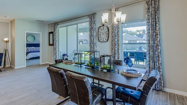 dining area with wood-type flooring and an inviting chandelier