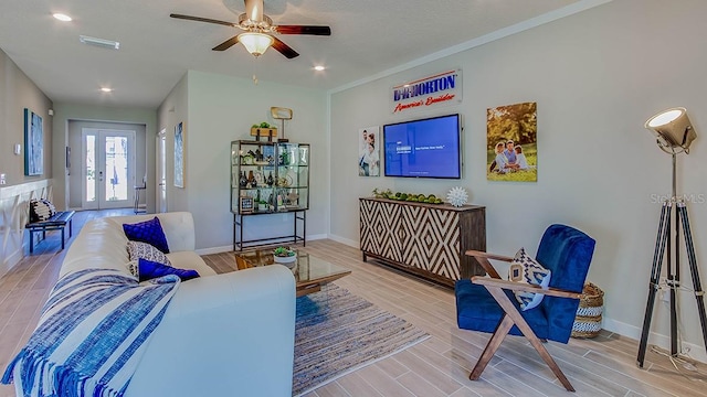 living room with ceiling fan, ornamental molding, french doors, and hardwood / wood-style floors