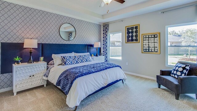 carpeted bedroom with ceiling fan and multiple windows