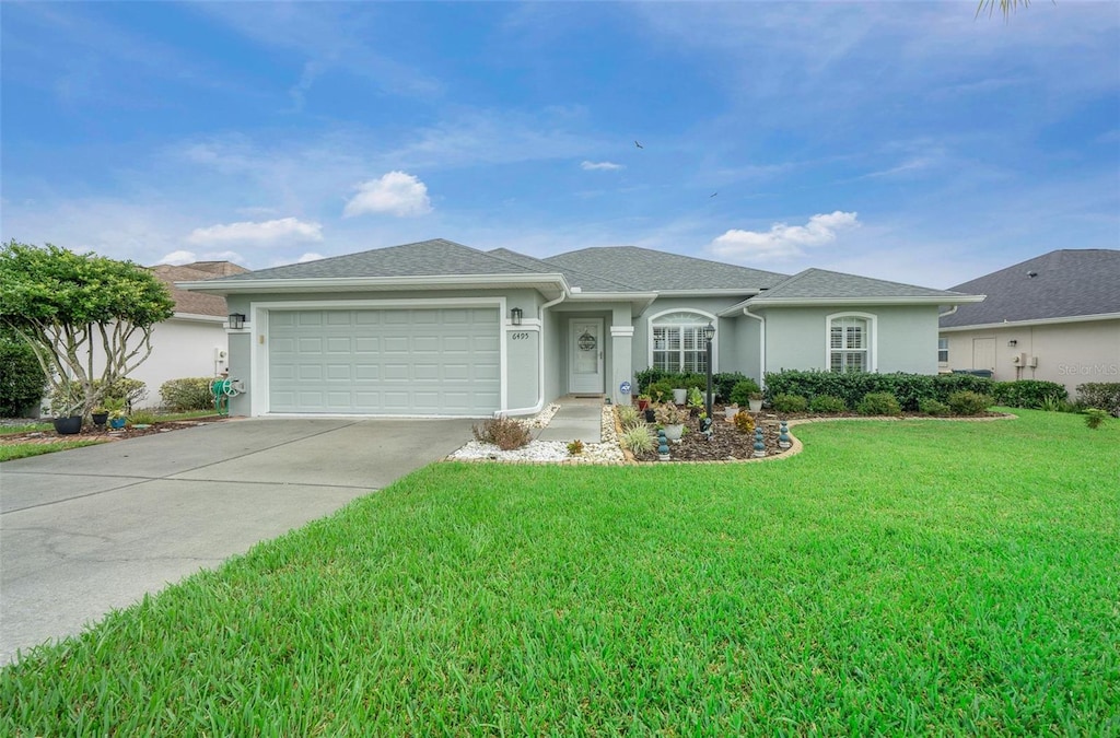 ranch-style home featuring a garage and a front lawn