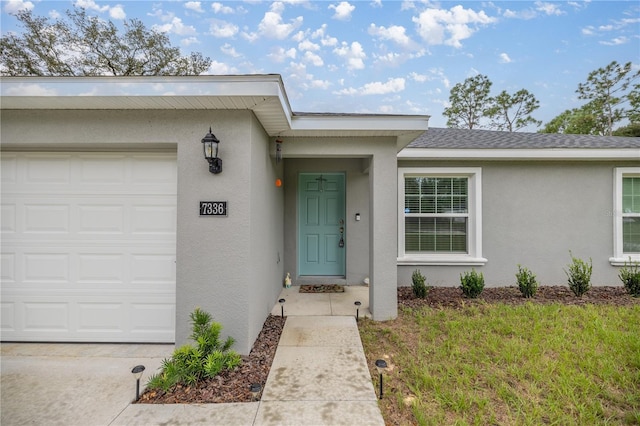 view of exterior entry with a garage and a yard