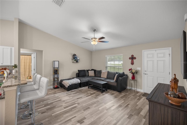 living room with ceiling fan, lofted ceiling, and light hardwood / wood-style floors