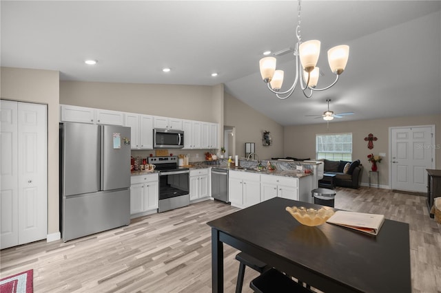 kitchen featuring stainless steel appliances, kitchen peninsula, hanging light fixtures, and white cabinets