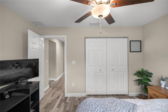 bedroom featuring ceiling fan, a closet, and light hardwood / wood-style flooring