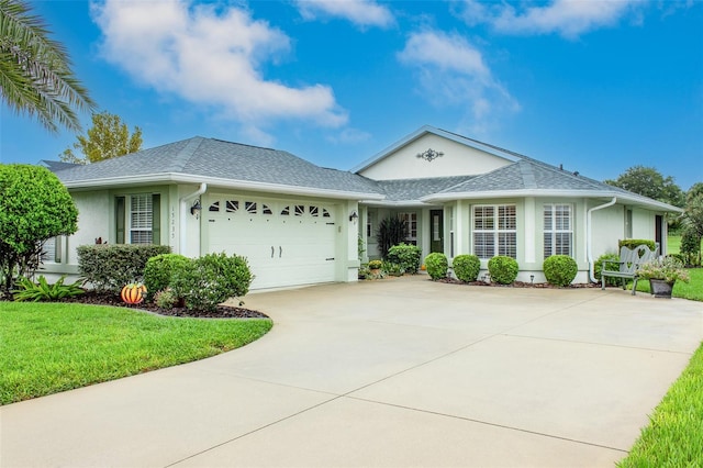 single story home with a garage and a front lawn