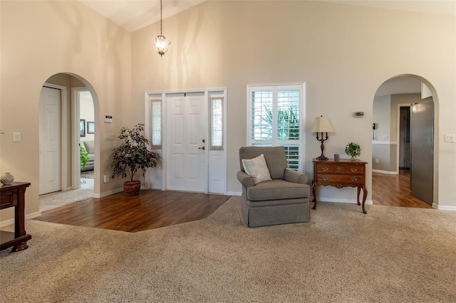 foyer entrance with hardwood / wood-style flooring and high vaulted ceiling