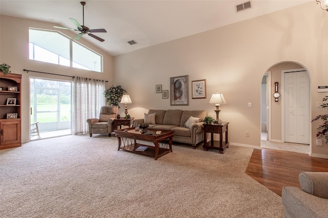 living room with wood-type flooring, high vaulted ceiling, and ceiling fan