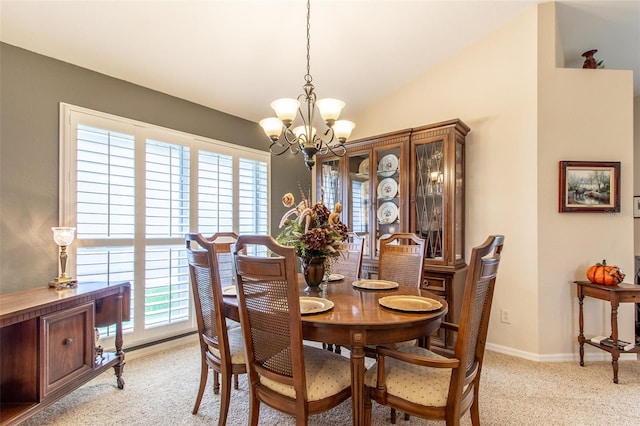 carpeted dining space with an inviting chandelier, lofted ceiling, and a healthy amount of sunlight