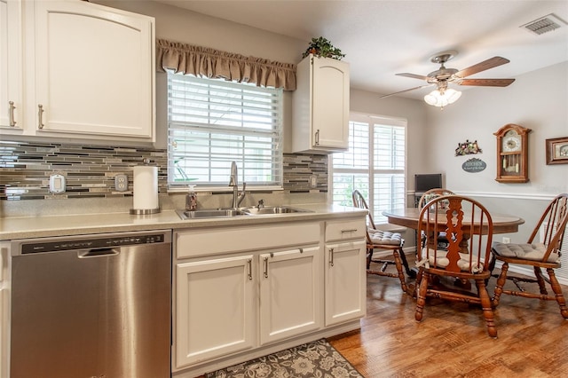 kitchen with sink, tasteful backsplash, white cabinetry, dishwasher, and light hardwood / wood-style floors