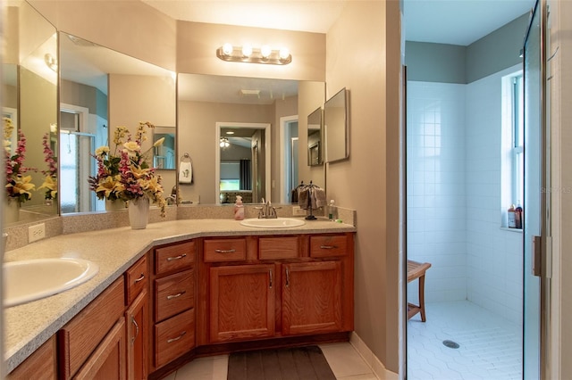 bathroom with vanity, tile patterned flooring, and a tile shower