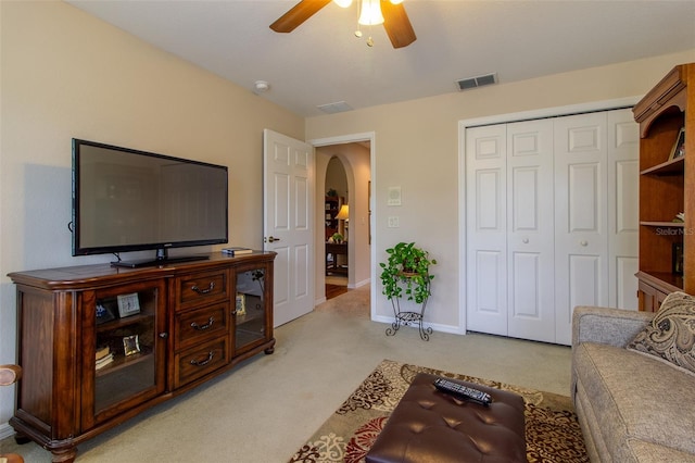 carpeted living room with ceiling fan