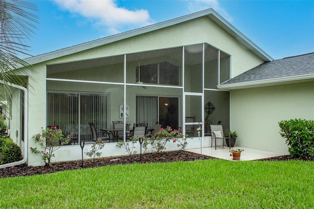 back of house featuring a yard, a sunroom, and a patio area