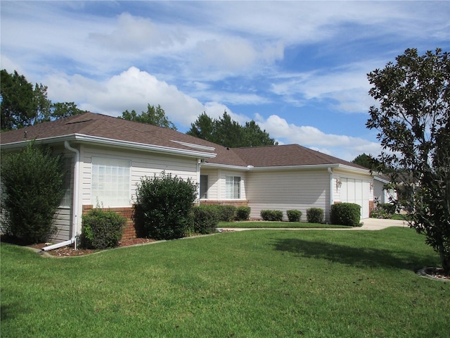 exterior space with a garage, a front lawn, and brick siding