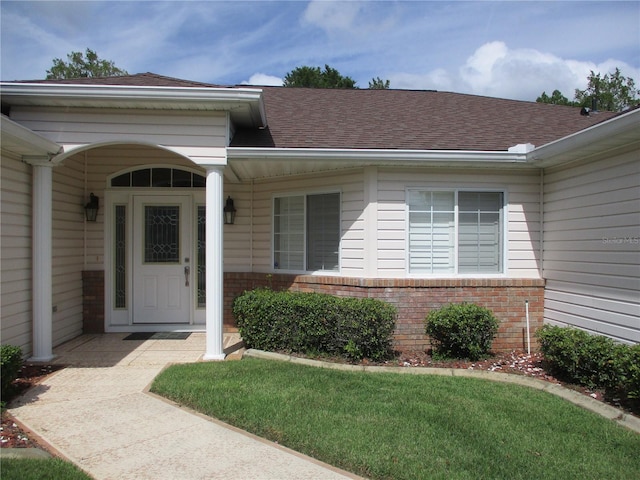 property entrance with brick siding and roof with shingles