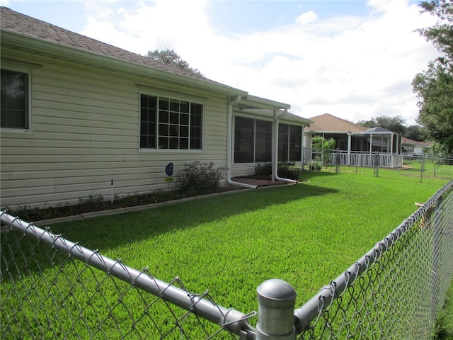 view of yard featuring a sunroom and a fenced backyard