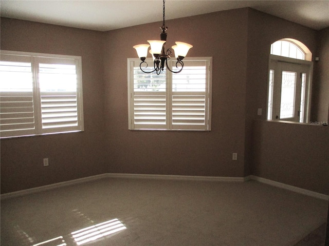 unfurnished dining area featuring carpet flooring, vaulted ceiling, baseboards, and an inviting chandelier