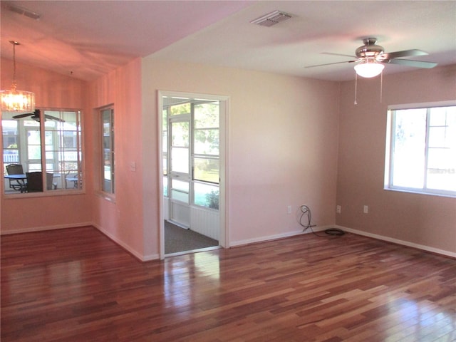 spare room with a wealth of natural light, visible vents, and wood finished floors