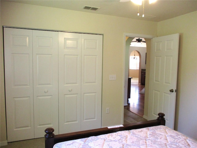 unfurnished bedroom featuring arched walkways, a closet, and visible vents