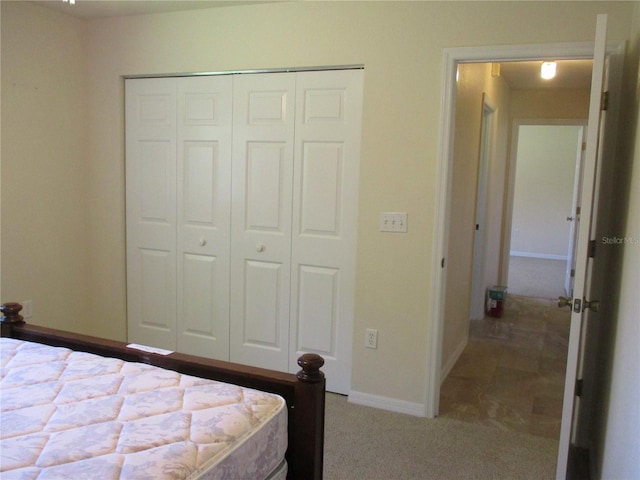 unfurnished bedroom featuring baseboards, a closet, and carpet flooring