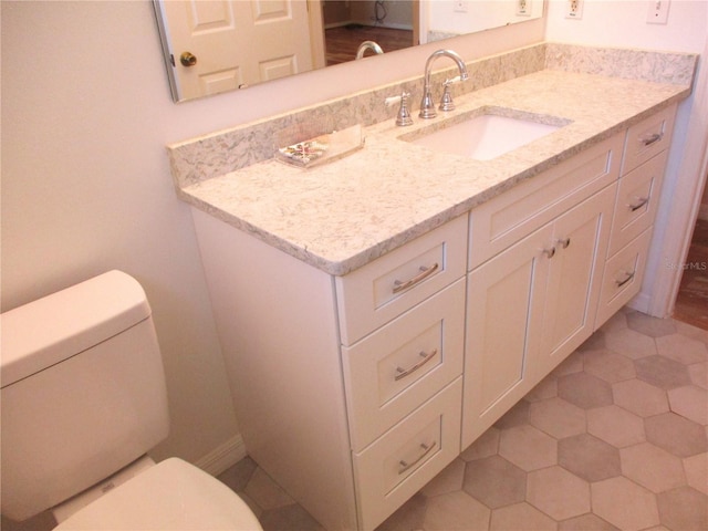 bathroom with tile patterned floors, vanity, toilet, and baseboards