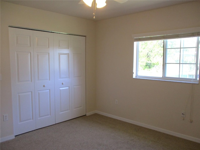 unfurnished bedroom featuring light carpet, a closet, and baseboards