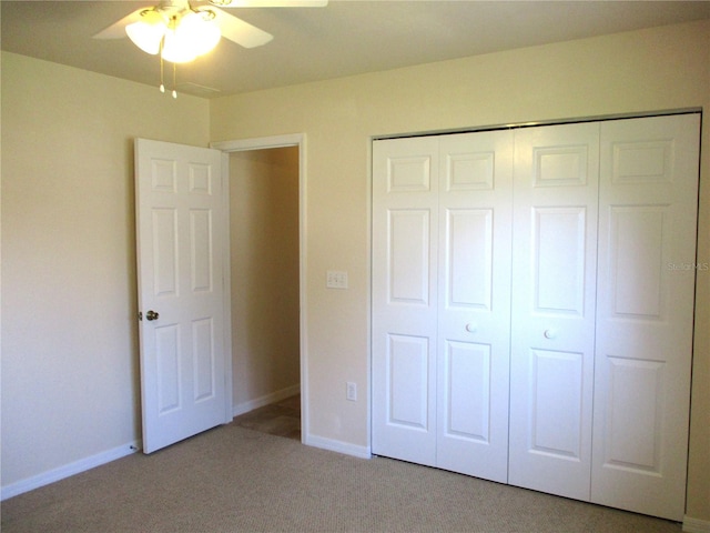 unfurnished bedroom featuring carpet floors, a closet, baseboards, and a ceiling fan