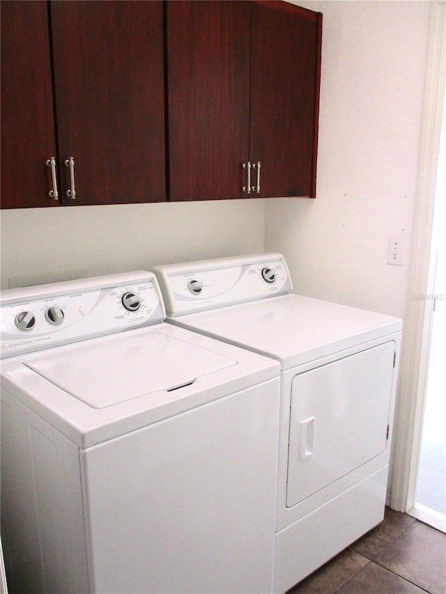 clothes washing area featuring washing machine and clothes dryer and cabinet space