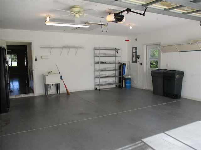 garage with a sink, electric panel, and a garage door opener