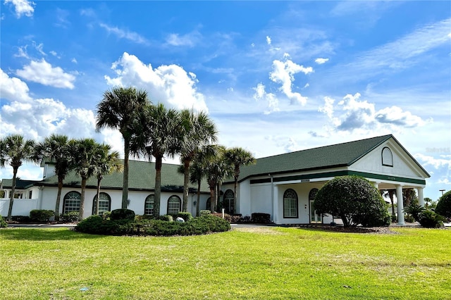 view of front facade with a front yard and stucco siding