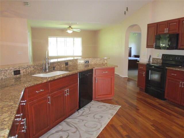 kitchen with a sink, black appliances, arched walkways, dark wood-style flooring, and visible vents