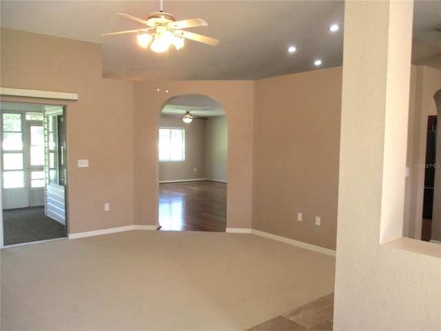 unfurnished room with arched walkways, ceiling fan, recessed lighting, baseboards, and carpet