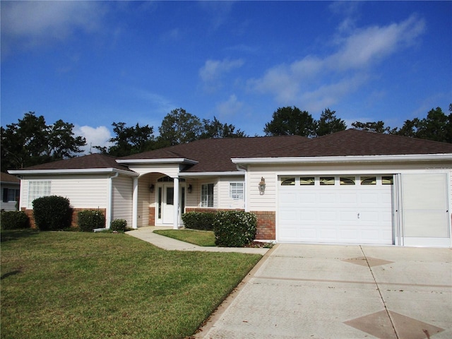 ranch-style home with a garage, brick siding, driveway, and a front lawn