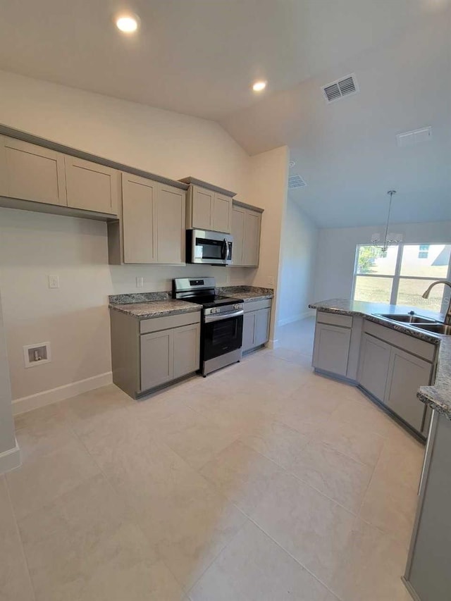 kitchen with stainless steel appliances, sink, stone counters, and gray cabinetry