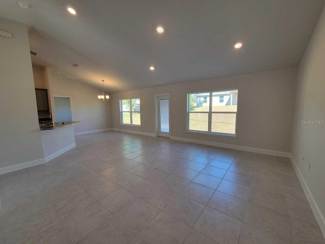 unfurnished living room featuring a notable chandelier, lofted ceiling, and light tile patterned floors