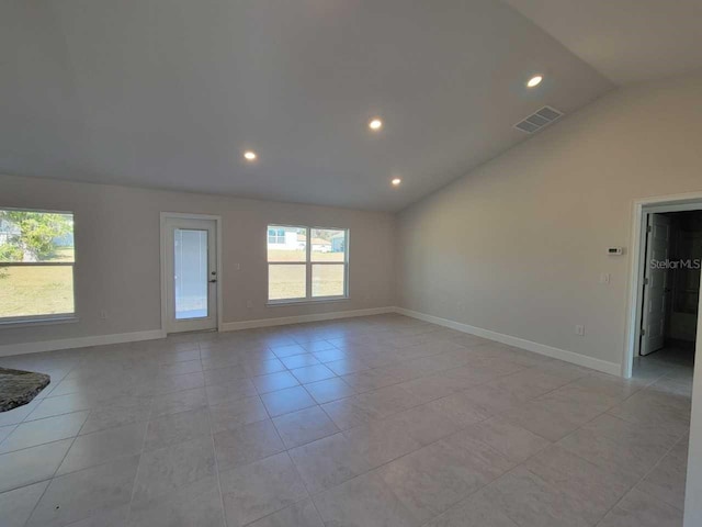 tiled spare room with vaulted ceiling