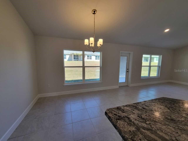 unfurnished dining area with an inviting chandelier and light tile patterned flooring