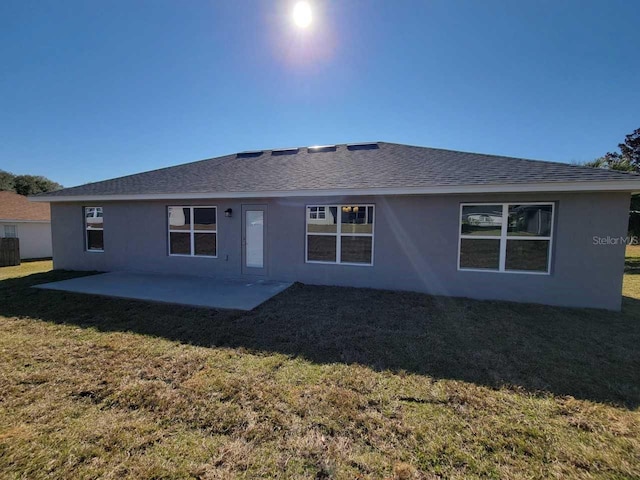 back of house with a patio area and a lawn