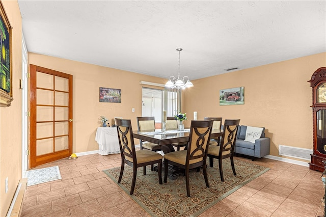 dining room featuring light tile patterned flooring, an inviting chandelier, and a textured ceiling