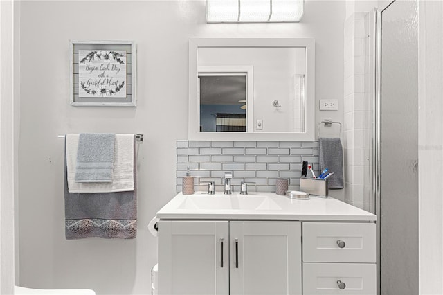 bathroom with an enclosed shower, toilet, vanity, and tasteful backsplash