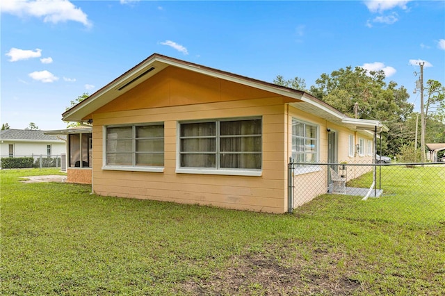 view of home's exterior featuring a sunroom and a lawn