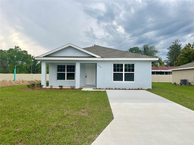 view of front of home with a front yard and central AC