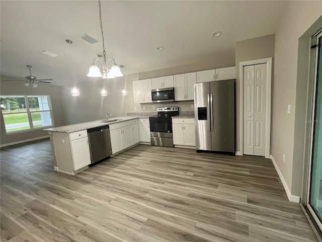 kitchen with white cabinetry, stainless steel appliances, sink, and hanging light fixtures